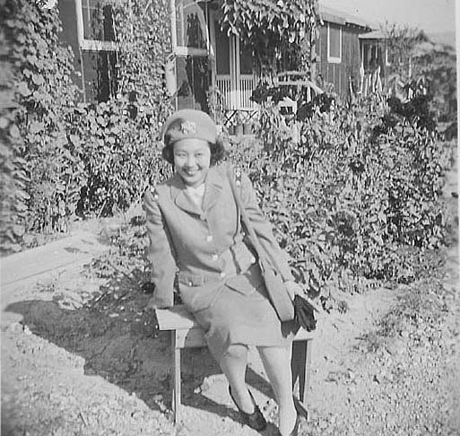 Woman in United States Cadet Nurse Corps uniform sitting in garden, Rohwer, Arkansas, September 23, 1944