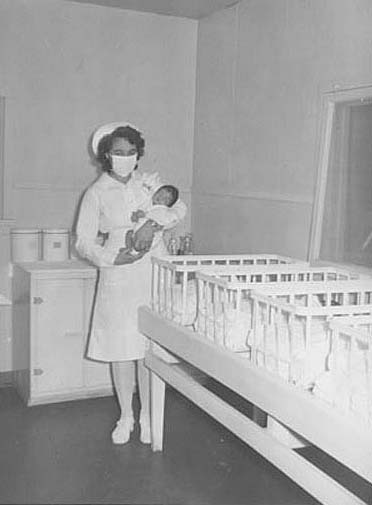 Nurse carrying newborn infant, Rohwer, Arkansas
